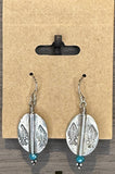 Silver leaf-shaped earrings with blue beads on a cardboard backing