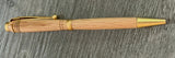 Wooden pen with gold accents on a wooden surface