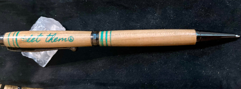 Wooden pen with engraved text on a dark background