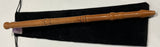 Wooden wand with a black pouch on a white surface