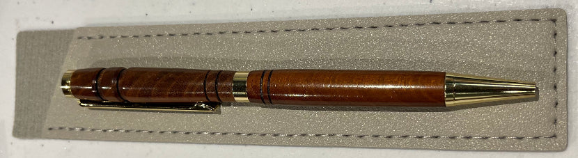 Wooden pen on a gray fabric patch with a white background