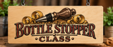 Laser-engraved wooden Bottle Stopper Class sign featuring a handcrafted bottle stopper, decorative wood shavings, and vintage lettering in a rustic woodworking studio.